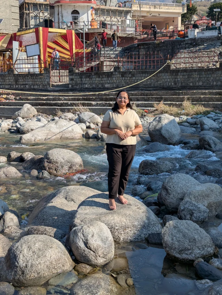 Preeti Gupta standing on a rock in a river